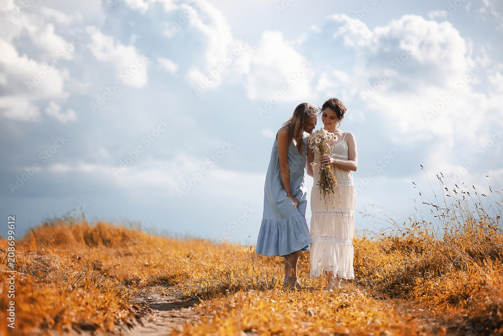 Two girls in dresses in autumn field Two girls in dresses in autumn field