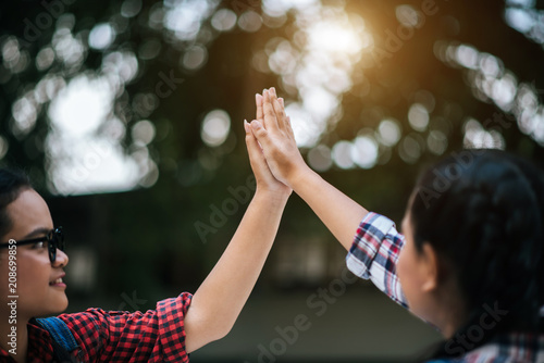 Two girls college student giving high five celebrating