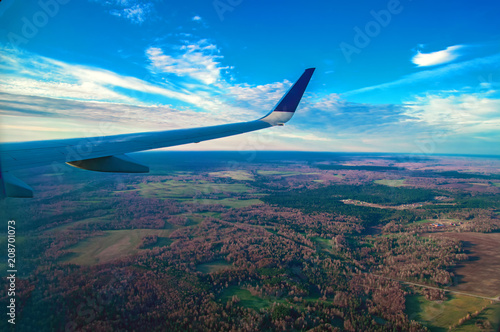 Beautiful landscape of forests with a bird's-eye view. Wing Through Plane passenger Window. Panoramic view.