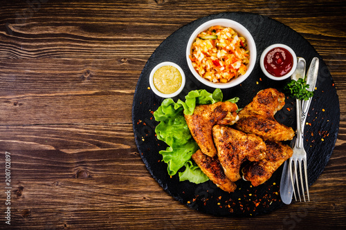 Chicken wings with French fries on wooden background 