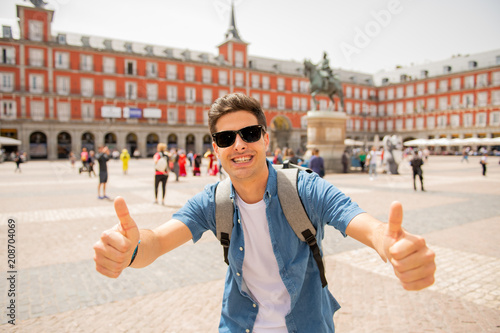 Handsome young caucasian tourist man happy and excited taking a selfie in Plaza Mayor, Madrid Spain