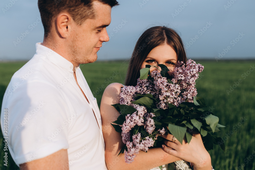 The lovely couple in love embracing and keeping bouquet The lovely couple in love embracing and keeping bouquet