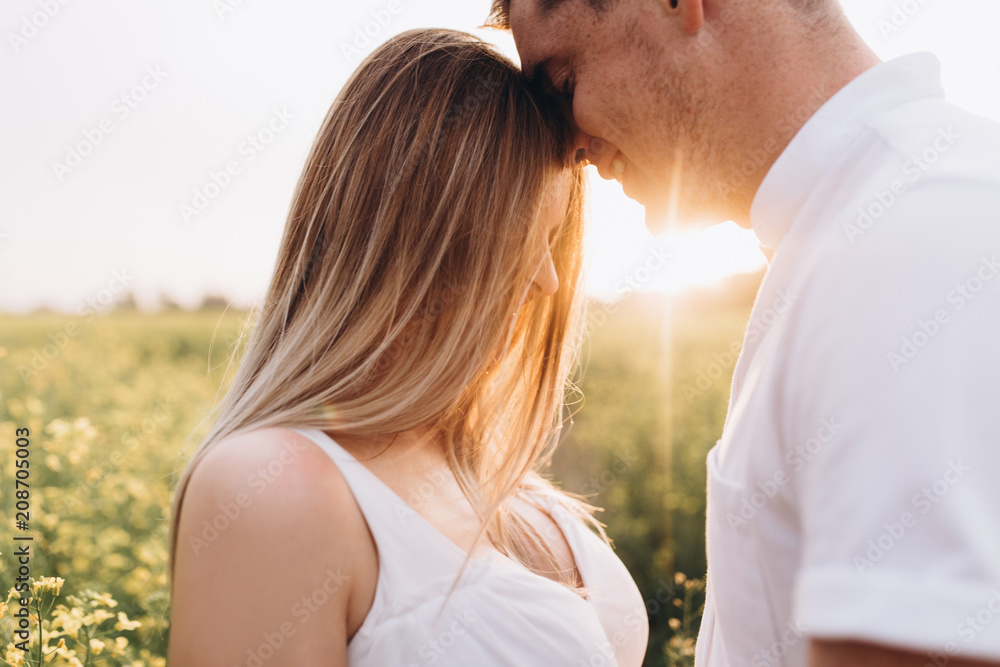 The husband kissing his wife and standing on the field The husband kissing his wife and standing on the field