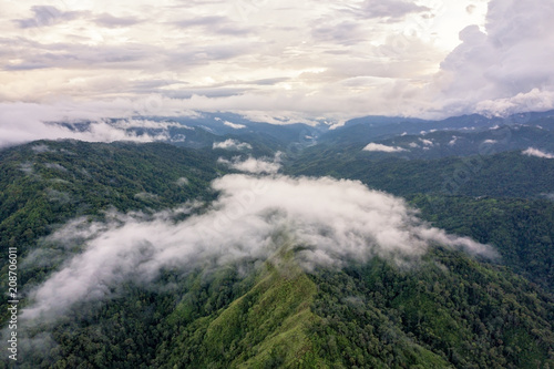 Aerial view of Mountain surrounded by clouds and fog, misty landscape with mountains and trees in the forest on rainy season. Amazing nature landscape.