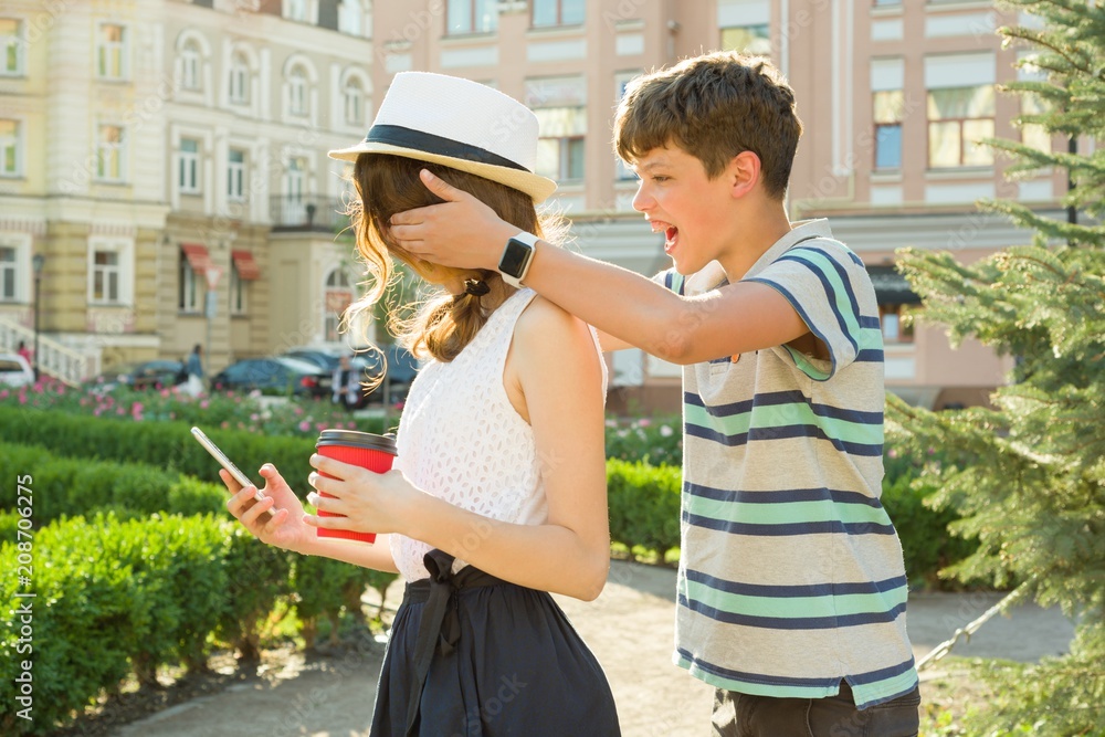 Friends are teenagers. The boy at the meeting closed the girl's eyes with his hands, made surprise Friends are teenagers. The boy at the meeting closed the girl's eyes with his hands, made surprise