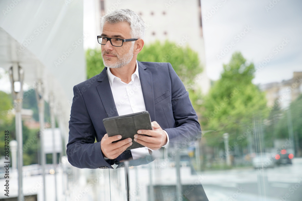 Businessman in city street connected with digital tablet Businessman in city street connected with digital tablet
