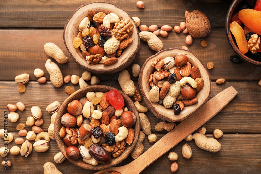 Bowls with various tasty nuts on wooden table Bowls with various tasty nuts on wooden table