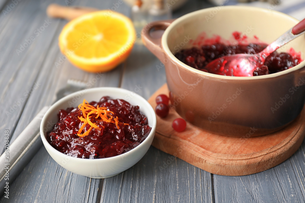 Bowl and pot with tasty cranberry sauce on table Bowl and pot with tasty cranberry sauce on table
