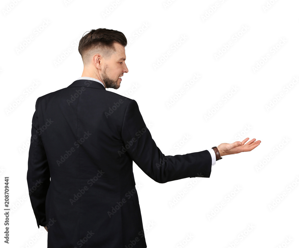 Young businessman holding something on gray background Young businessman holding something on gray background