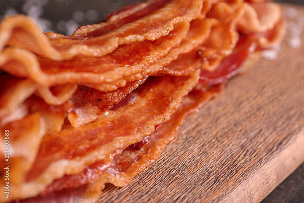 Tasty fried bacon on wooden board, closeup Tasty fried bacon on wooden board, closeup