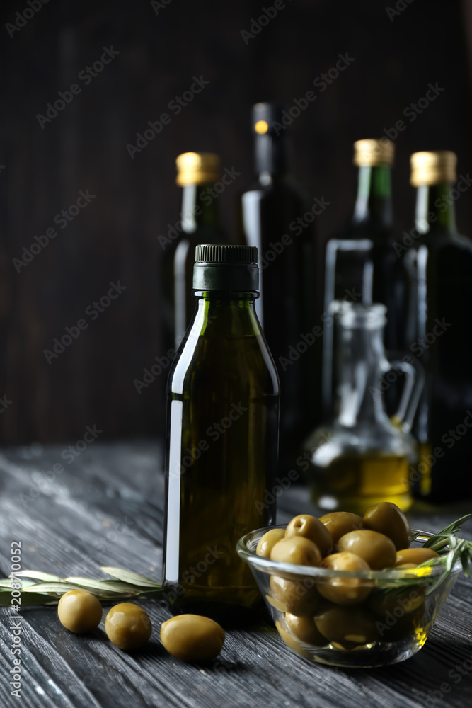 Composition with olives and oil in bottle on dark background Composition with olives and oil in bottle on dark background