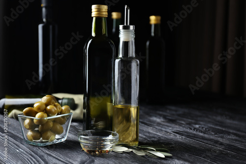 Composition with olives and oil on dark background