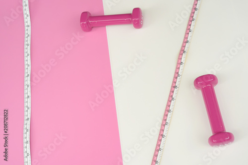 Fitness concept dumbbell and measuring tape for background © thananya_k