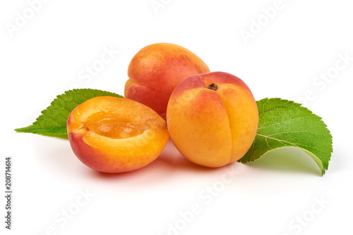Fresh whole apricots with leaf and half, isolated on white background.