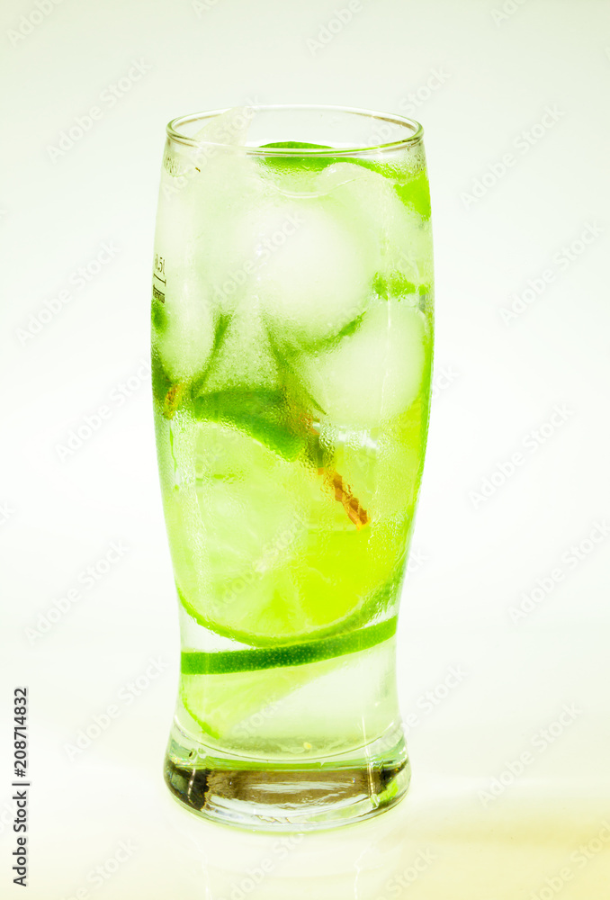 summer cold drink mojito lime and mint with ice and soda with drops on a glass on a white background summer cold drink mojito lime and mint with ice and soda with drops on a glass on a white background