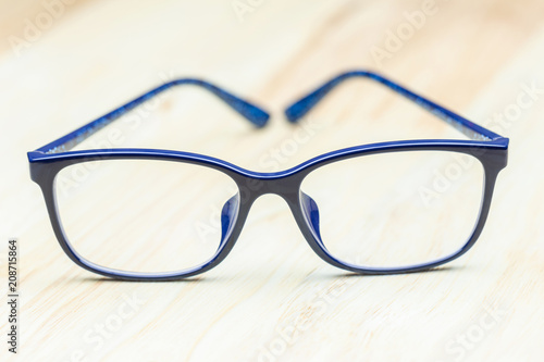 Blue eye glasses on wood table for business, education concept design.