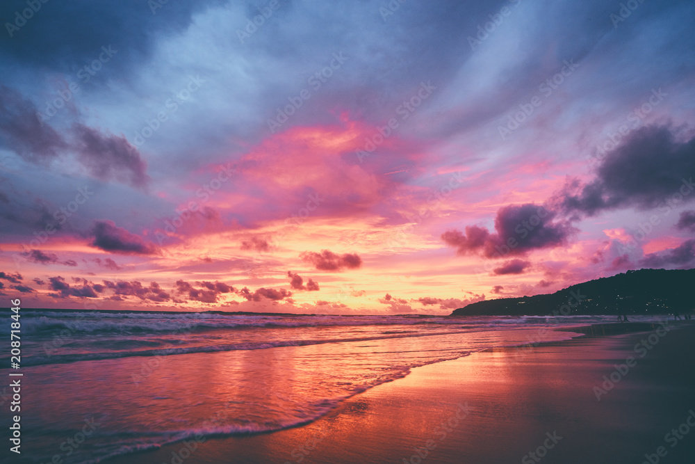 Naklejka premium Piękny zachód słońca na plaży oceanu. Niebo odbija się w wodzie.