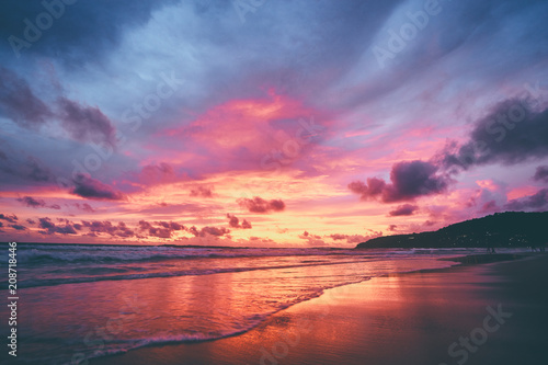 Beautiful sunset on ocean beach. Sky is reflecting at water. © luengo_ua