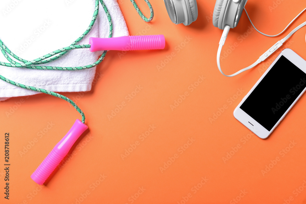 Flat lay composition with jumping rope, smartphone and towel on color background. Gym workout Flat lay composition with jumping rope, smartphone and towel on color background. Gym workout