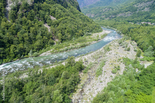 Alpine river seen from above. In summer the river gets thicker due to the thaw of the glaciers. Top view of the river Sesia in Piedmont, Italy. © Arcansél