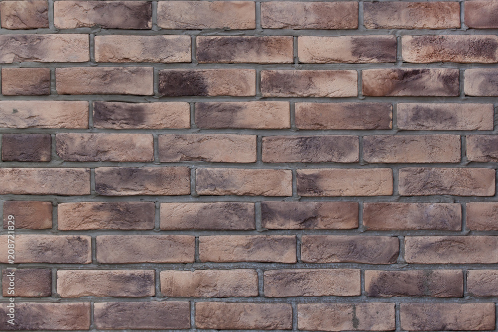 Brick wall with variegated brown bricks. Used as a background. Brick wall with variegated brown bricks. Used as a background.