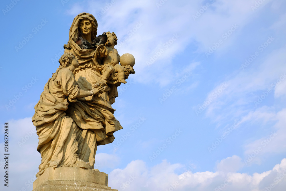 Statue on Charles bridge in Prague against blue sky Statue on Charles bridge in Prague against blue sky