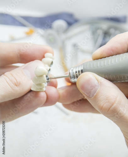 Dental technician making tooth prosthetic in laboratory close up