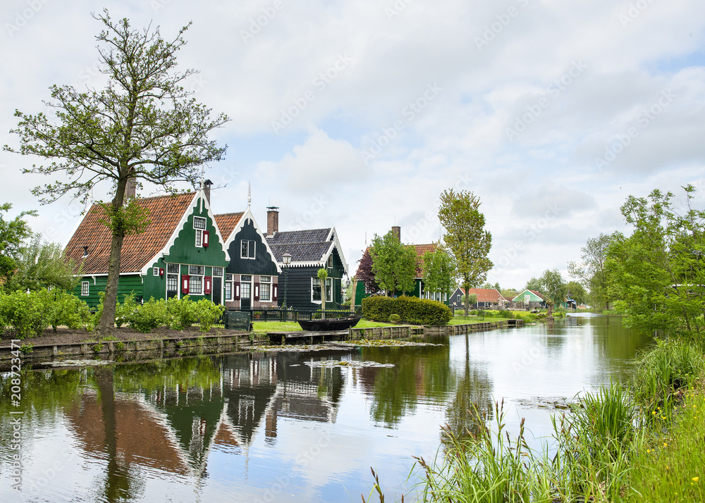 Pitoresque old dutch houses with clouded sky and a river in characteristic dutch landscape Pitoresque old dutch houses with clouded sky and a river in characteristic dutch landscape