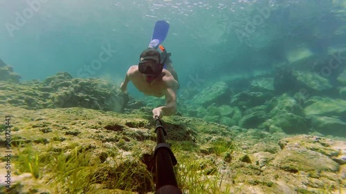 Young man dives with snorkel and shooting underwater video