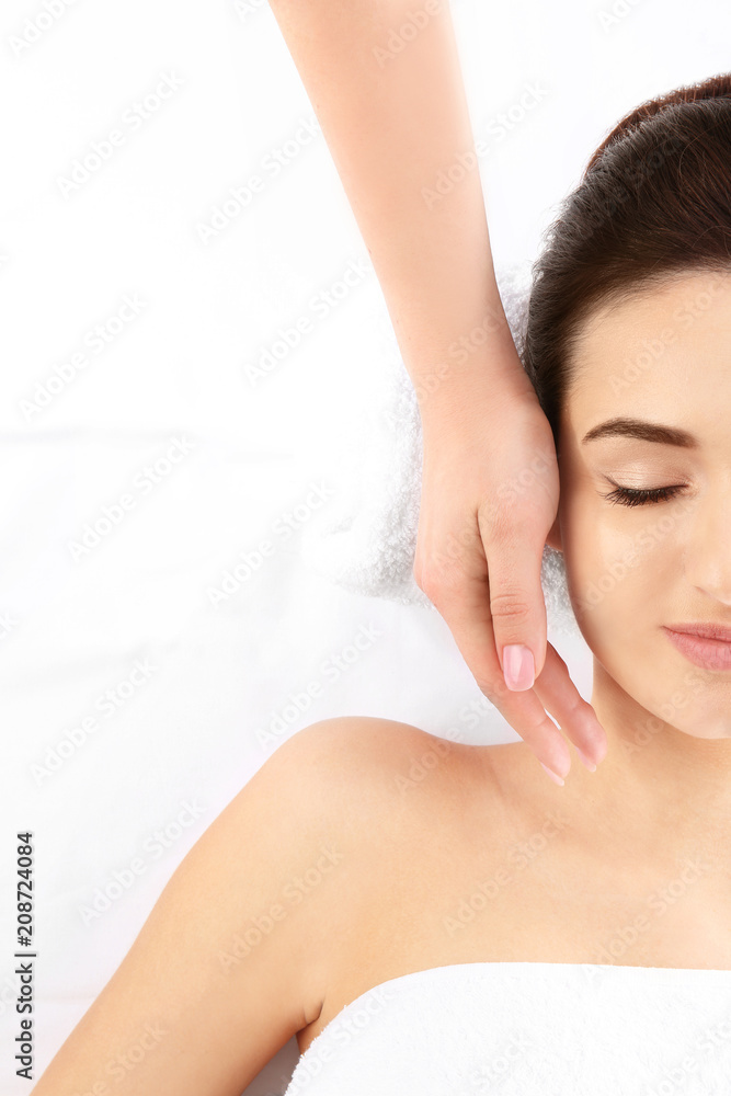 Young woman receiving face massage on white background, top view. Spa procedures