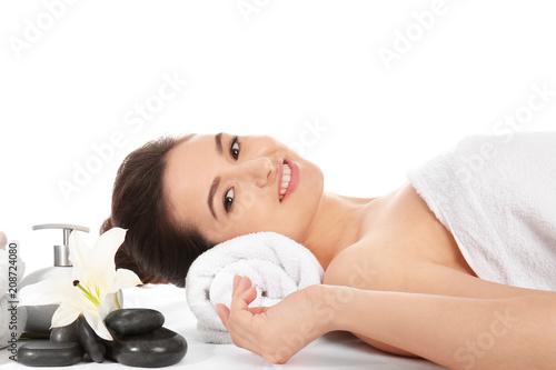 Young woman and spa accessories on white background