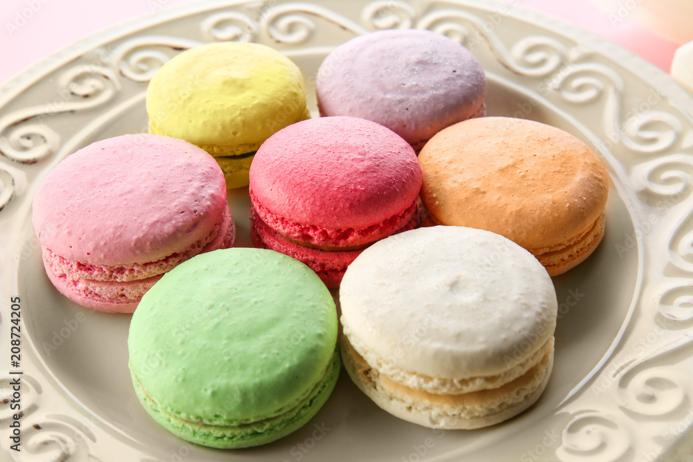 Plate with tasty macarons on color background Plate with tasty macarons on color background