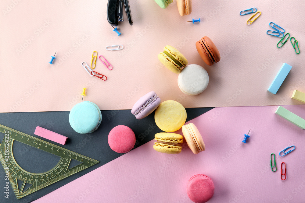 Flat lay composition with delicious macarons and stationery on color background