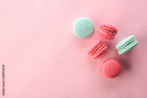 Tasty macarons on color background, top view