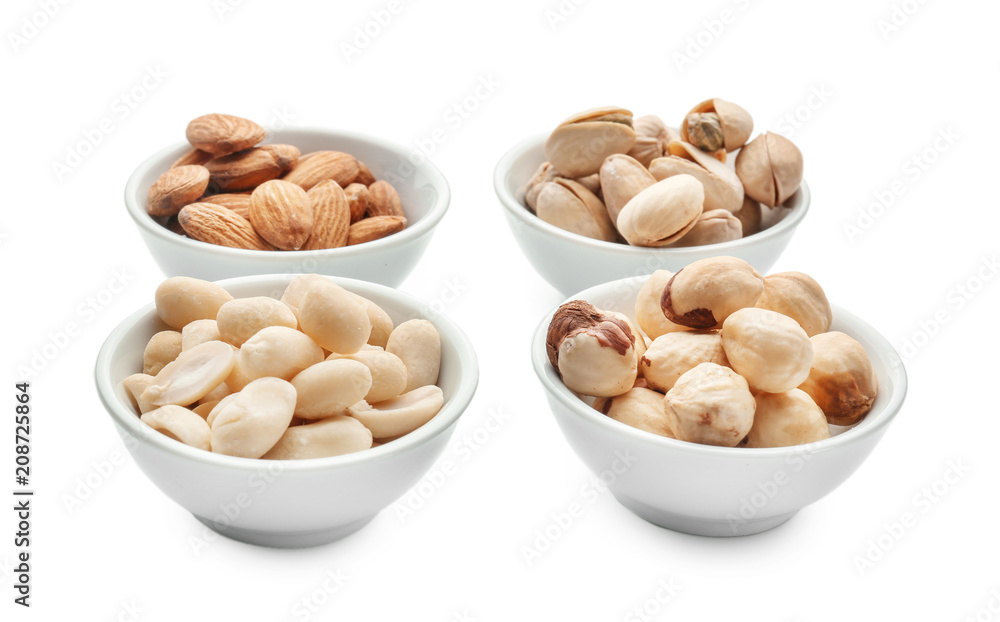 Different nuts in bowls on white background Different nuts in bowls on white background