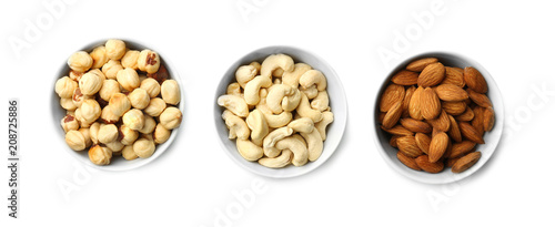 Different nuts in bowls on white background