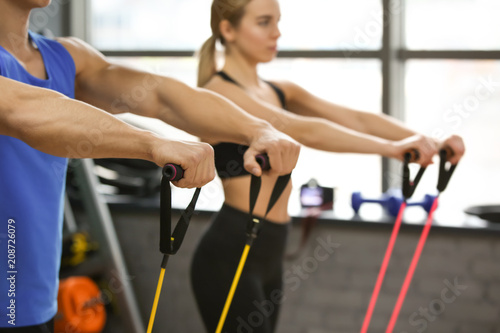 Young sporty woman and man training in modern gym, closeup © Pixel-Shot