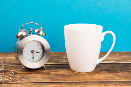 clock and coffee cup with blue background