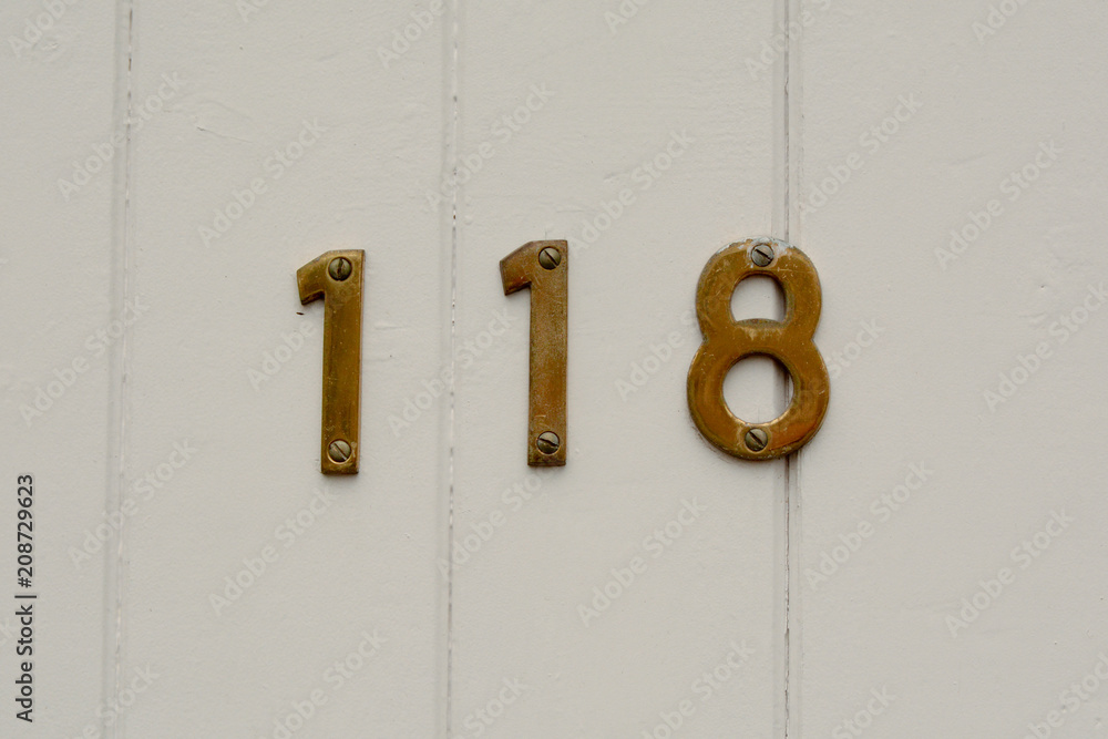 House number 118 sign on wooden door House number 118 sign on wooden door