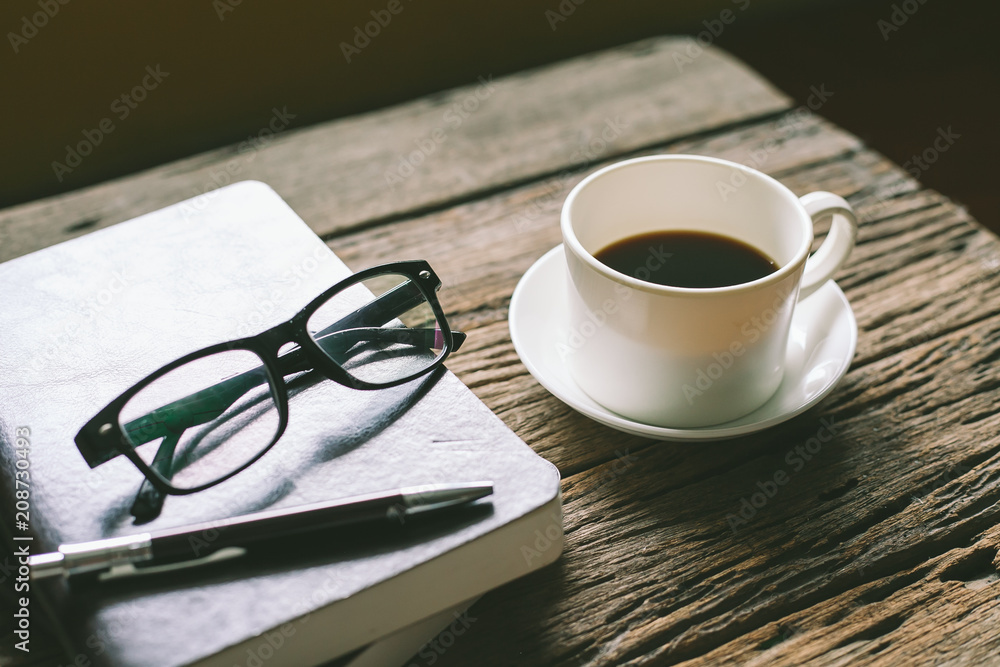 cup of coffee with glasses and book on wooden table cup of coffee with glasses and book on wooden table