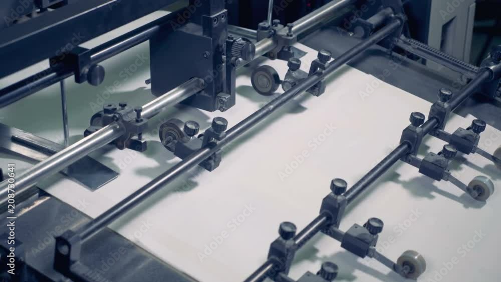 Paper recycle process. Paper move on a conveyor at a print office, close up. Paper recycle process. Paper move on a conveyor at a print office, close up.