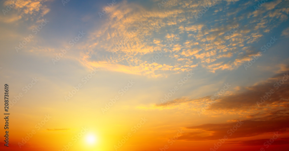 Cloudy sky and bright sun rise over the horizon. Wide photo.