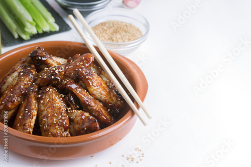 Traditional Asian stir fry chicken wings with sesame and vegetables. Copy space for text