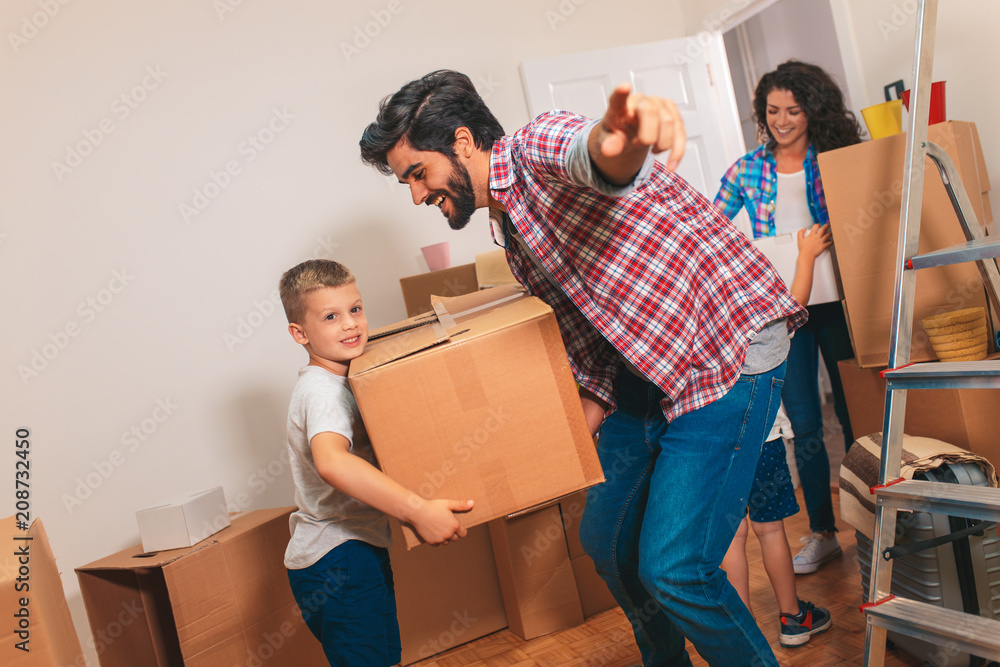 Happy young family moving into their new home. They carrying boxes into the apartment. Happy young family moving into their new home. They carrying boxes into the apartment.