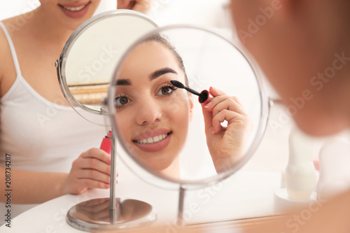 Young beautiful woman apply...