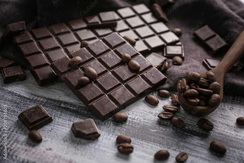 Composition with dark chocolate and coffee beans on table Composition with dark chocolate and coffee beans on table
