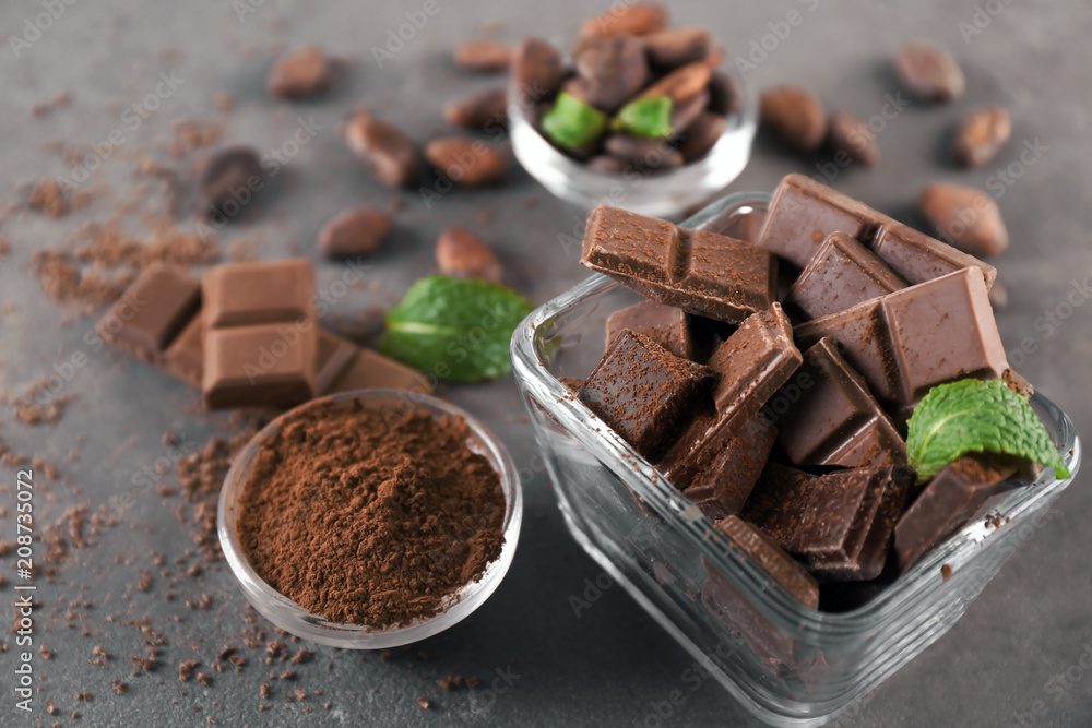 Bowls with tasty chocolate and cocoa powder on table Bowls with tasty chocolate and cocoa powder on table