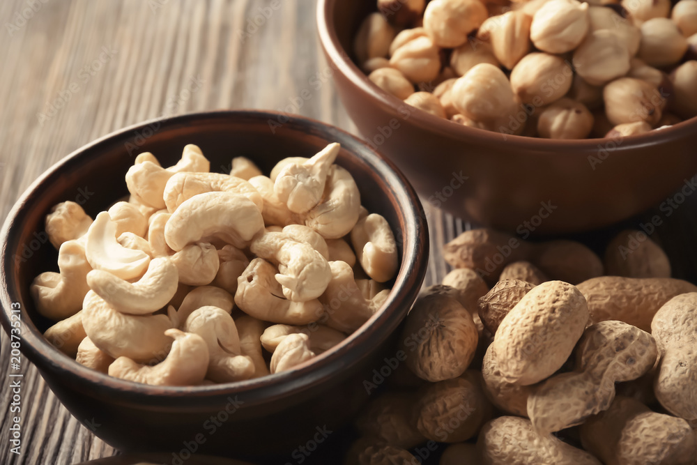 Bowls with different nuts on wooden table Bowls with different nuts on wooden table