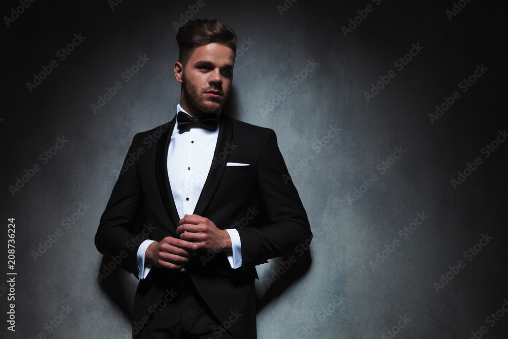 sexy man in black tuxedo holding hands together sexy man in black tuxedo holding hands together
