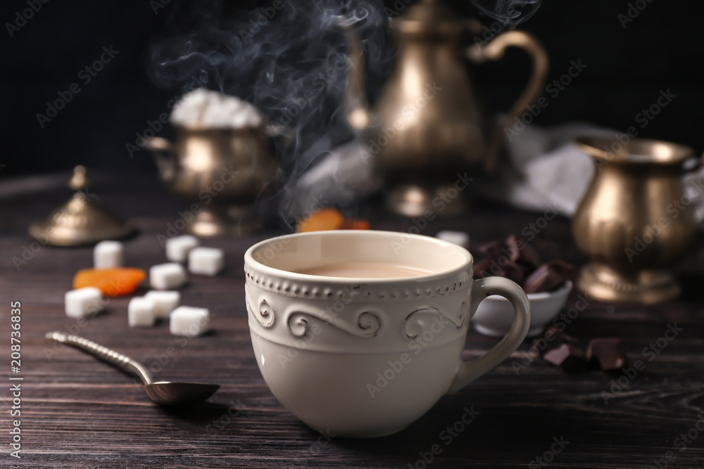 Cup of aromatic tea with milk on table Cup of aromatic tea with milk on table